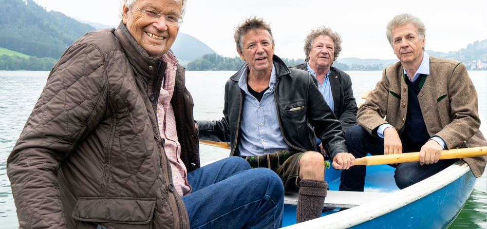 Gerhard Polt & die Well-Brüder aus´m Biermoos sitzen gemeinsam in einem Ruderboot.
