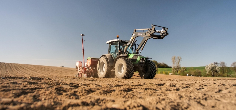 Traktor fährt über ein unbestelltes Feld
